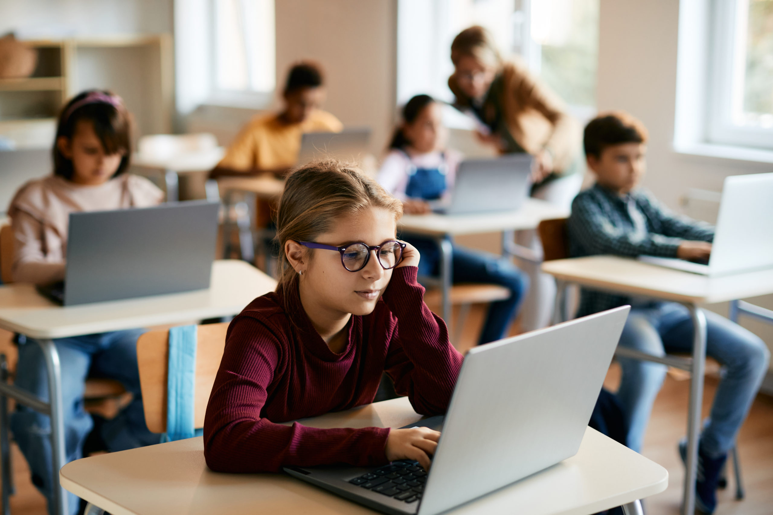 Schoolgirl using laptop during computer class to take an assessment at elementary school.